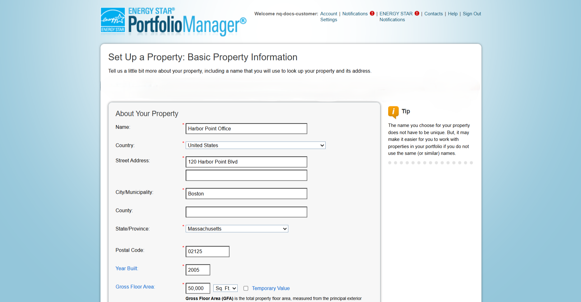 The Set Up a Property: Basic Property Information page in Portfolio Manager. The About Your Property panel shows a filled form: Name, Country set to United States, Street Address, City, State set to Massachusetts, Postal Code, Year Built, and Gross Floor Area with a Sq. Ft. unit selector and a Temporary Value checkbox. A Tip panel on the right notes that the property name does not have to be unique.